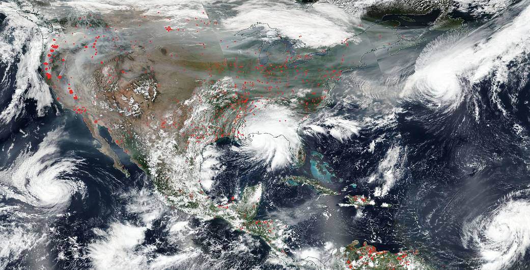 Tropical storms and billowing wildfire smoke rage within the the same NASA satellite photo